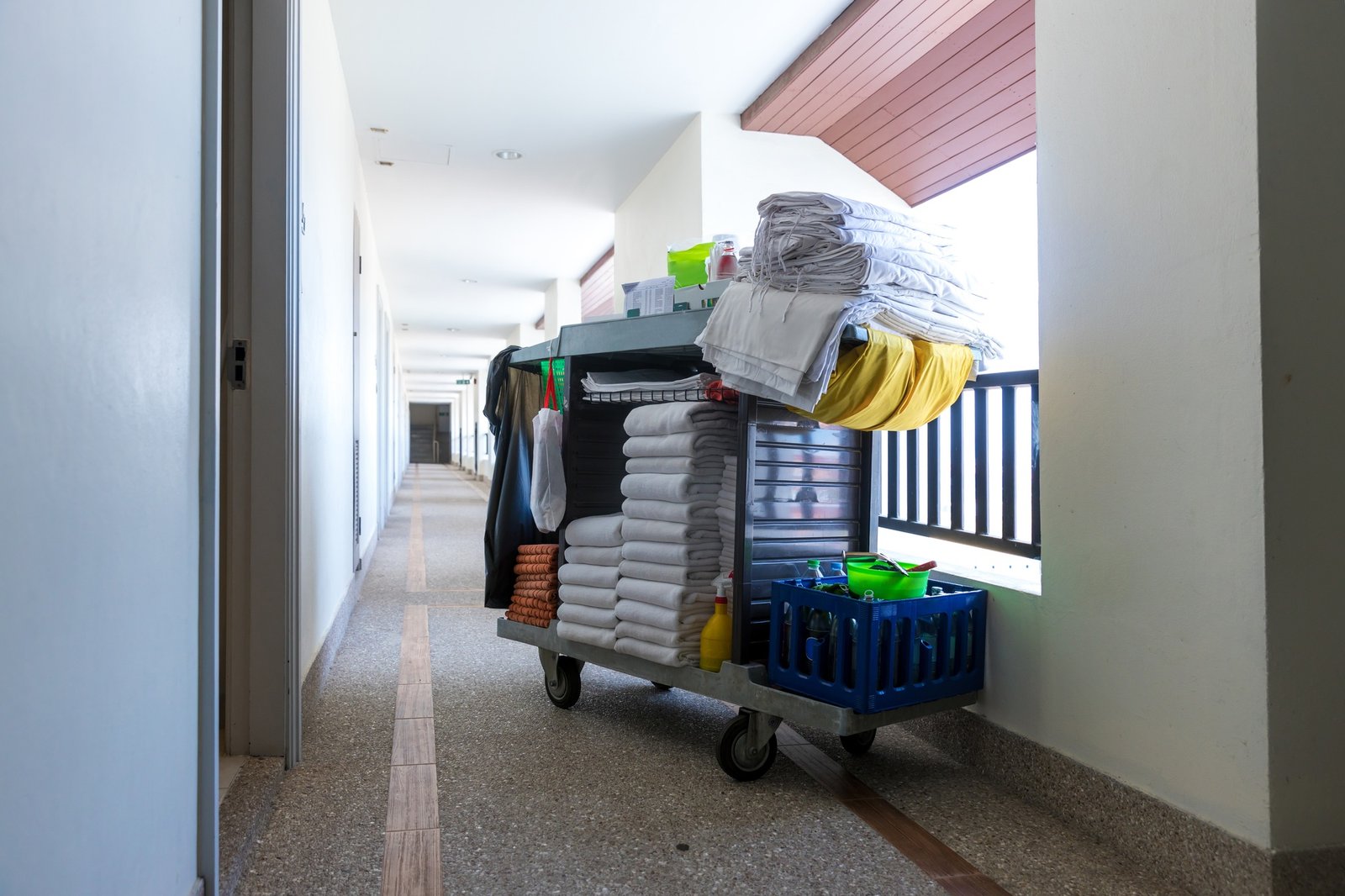 The hotel cleaning tool cart of housekeeper are on the walkway of resort area.